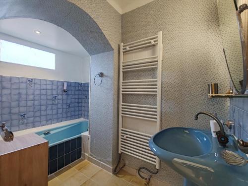 La salle de bains est pourvue d'un lavabo bleu et d'une baignoire. dans l'établissement Chambres d'hôtes L'Amphitryon 5 CHAMBRES, à Villemus