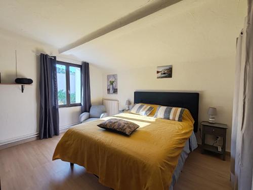 une chambre avec un lit avec un couvre-lit jaune dans l'établissement Chambres d'hôtes L'Amphitryon 5 CHAMBRES, à Villemus