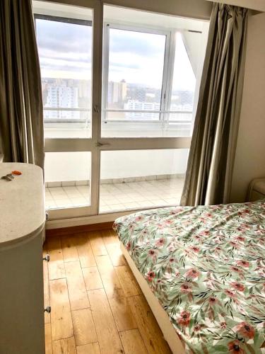 une chambre avec un lit et une grande fenêtre dans l'établissement Creteil new 1, à Créteil
