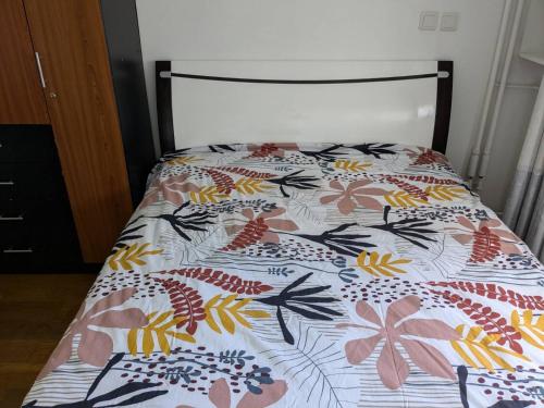 a bed with a bedspread with flowers on it at Creteil new 1 in Créteil