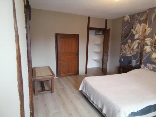 a bedroom with a bed and a wooden floor at Les Coquillages in Essoyes