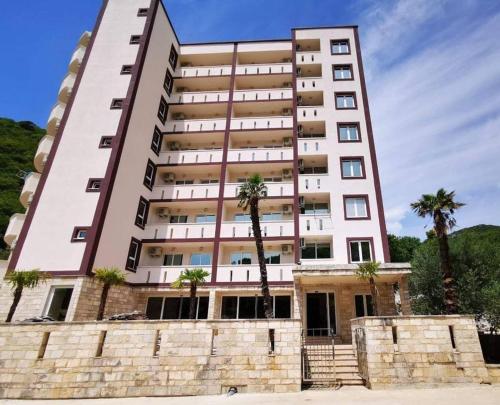 a tall building with palm trees in front of it at Dale apartment 61 in Budva