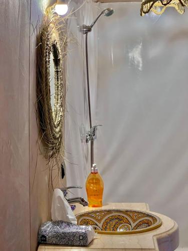 Un baño con lavabo y ducha con espejo. en Gorgeous Luxury Camp, en Merzouga
