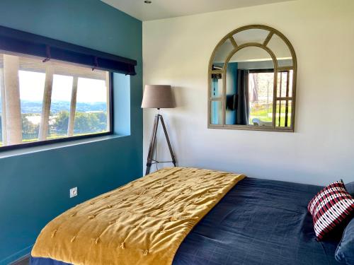 une chambre avec un lit et un miroir dans l'établissement Appartement Belle-vue, à Liginiac