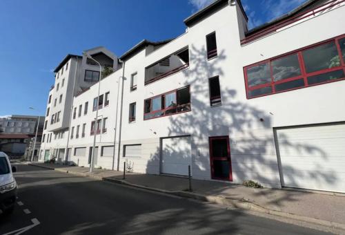 un bâtiment blanc au bord d'une rue dans l'établissement Appartement 2 chambres-garage Lyon Montchat, à Lyon