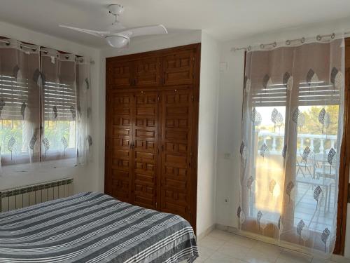 a bedroom with a bed and a window with curtains at COLOMBIA piscina privada in Miami Platja
