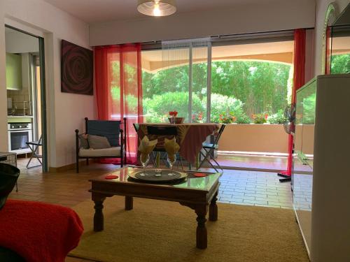 un salon avec une table et une grande fenêtre dans l'établissement Studio AZUR, à Six-Fours-les-Plages