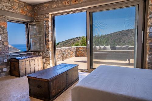 a bedroom with a bed and a view of the ocean at Kassis Mansion in Páliros