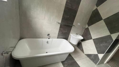 Un baño con bañera blanca y un inodoro. en Belz Boutique Hotel, en Ixopo