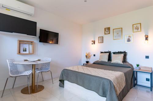 une chambre avec un lit et une table avec des chaises dans l'établissement Les Pierres De La Massane - Vue sur les Albères, à Argelès-sur-Mer