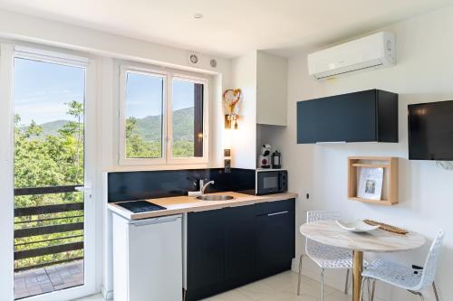 cocina con fregadero, mesa y ventana en Les Pierres De La Massane - Vue sur les Albères, en Argelès-sur-Mer