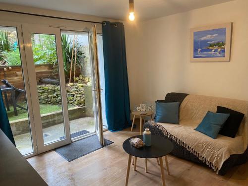 a living room with a couch and a sliding glass door at Un cocon face à la plage in Saint-Trojan-les-Bains