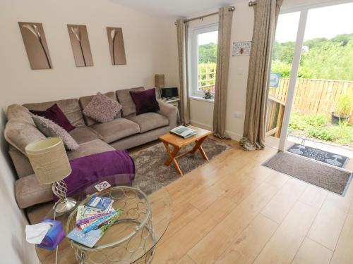 a living room with a couch and a table at Garden View in Pembroke