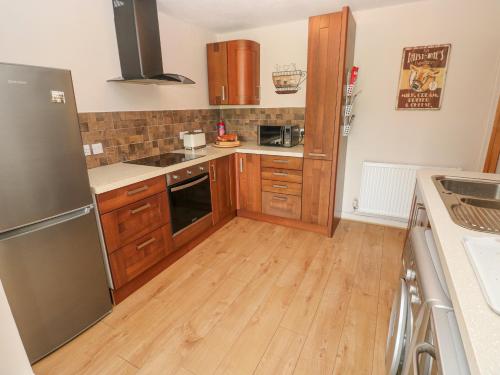 a kitchen with wooden cabinets and a wooden floor at Garden View in Pembroke