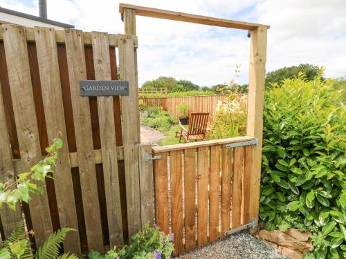 a wooden gate in a garden with a garden way sign at Garden View in Pembroke