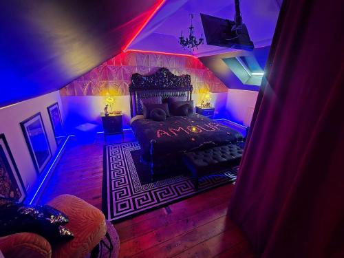 a bedroom with a bed with purple and blue lights at Maison équipée avec petit déjeuner gratuit - balnéo- sauna - siège massant et pièce secrète in Brachy