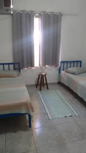 a room with two beds and a table and a window at Hotel Arbom in Mogi Guaçu