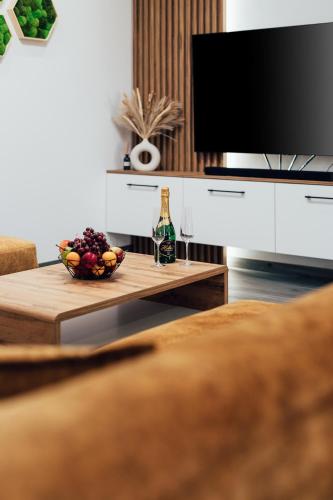 a living room with a television and a table with a bowl of fruit at Chaty ForRest in Valča