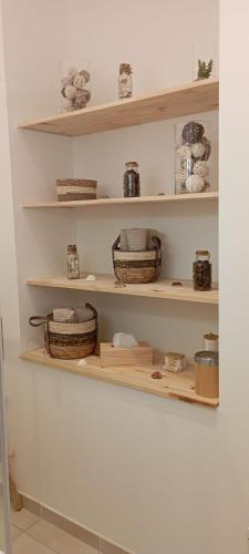 une étagère contenant des paniers et d'autres articles dans l'établissement La jade wifi climatisation arènes, à Nîmes