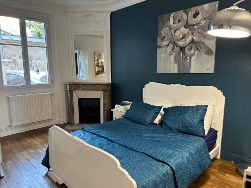 une chambre avec un lit et un mur bleu dans l'établissement Appartement calme près de La Villette, à Paris