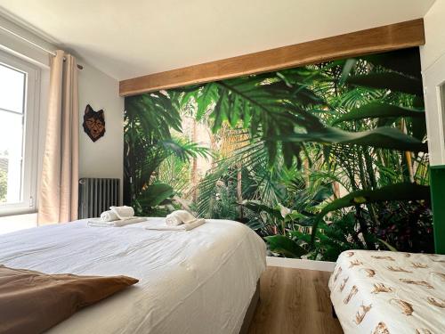 Un dormitorio con un mural tropical en la pared. en Le Toucan, en Saint-Aignan