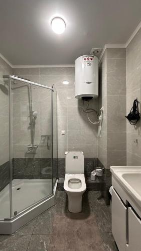 a bathroom with a shower and a toilet and a sink at Двух этажный таунхаус в 100 метрах от берега in Cholpon-Ata