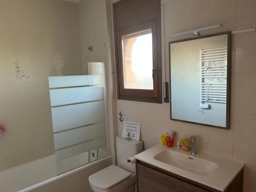 a bathroom with a toilet and a sink and a mirror at COLOMBIA piscina privada in Miami Platja
