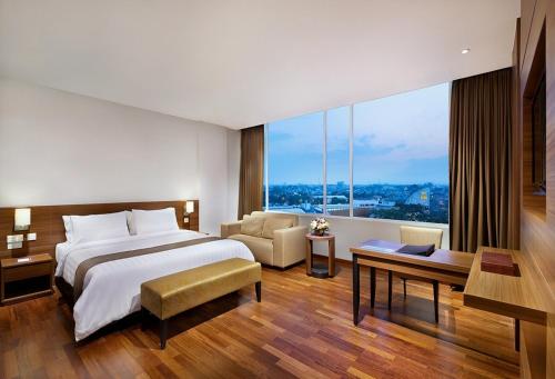 A bed or beds in a room at Grand Cakra Hotel Malang