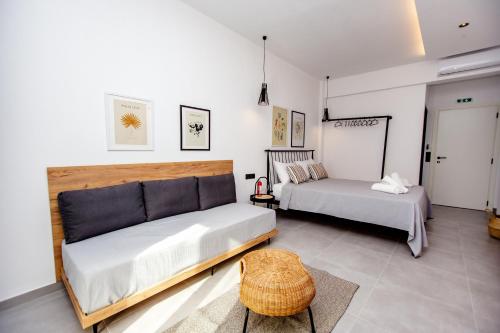 a bedroom with two beds and a stool in it at LA PLAZA luxury suites NEA VRASNA in Nea Vrasna