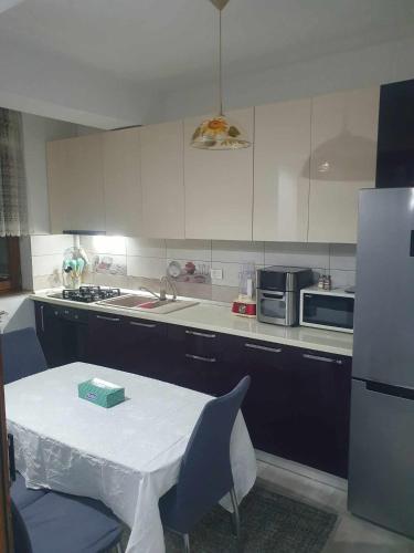 a kitchen with a table and a refrigerator at SYS Apartament in Constanţa