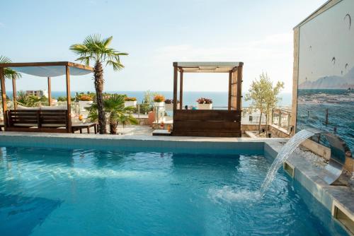 a swimming pool with a water fountain at Hotel Freiburg in Ulcinj