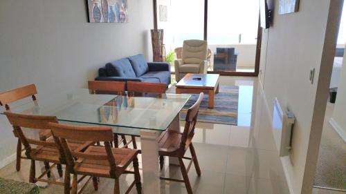 a dining room with a glass table and chairs at Jardin del Mar, Enjoy La Serena in Coquimbo