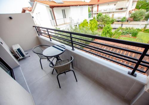 a balcony with a table and chairs and a view at LA PLAZA luxury suites NEA VRASNA in Nea Vrasna