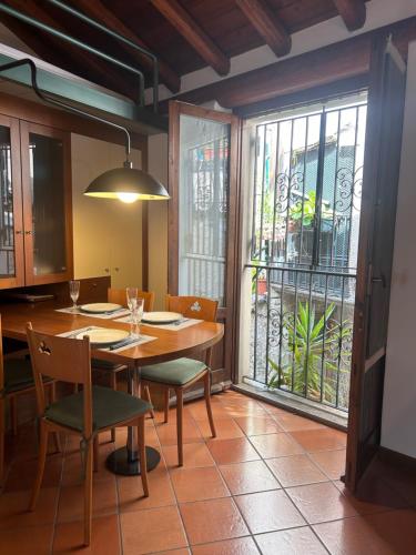 a dining room with a table and chairs and a window at Casa Borgo in Lenno