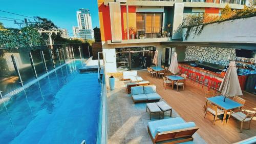 a swimming pool with chairs and tables and a building at Penthouse Ciudad de Guatemala zona 10 EON in Guatemala