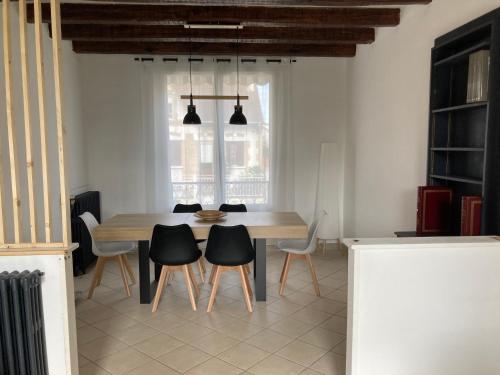 a dining room with a table and chairs at Belle maison avec grande terasse à 10 minutes en train de Paris centre et 6 min à pied de la gare et du centre ville in Colombes