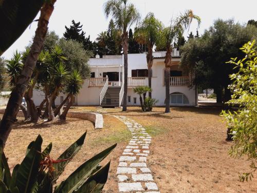 a house with palm trees and a stone path at Relais LaValle in Taranto