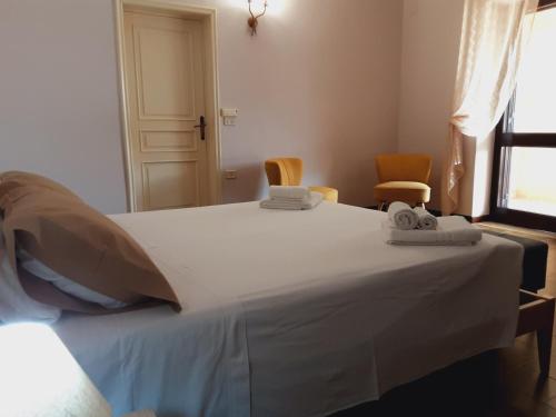 a bedroom with a large white bed with two chairs at Relais LaValle in Taranto