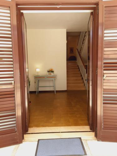 an open door to a hallway with a table and stairs at Relais LaValle in Taranto