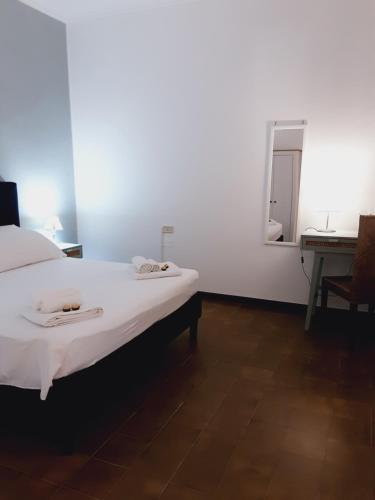 a bedroom with a bed and a desk and a mirror at Relais LaValle in Taranto