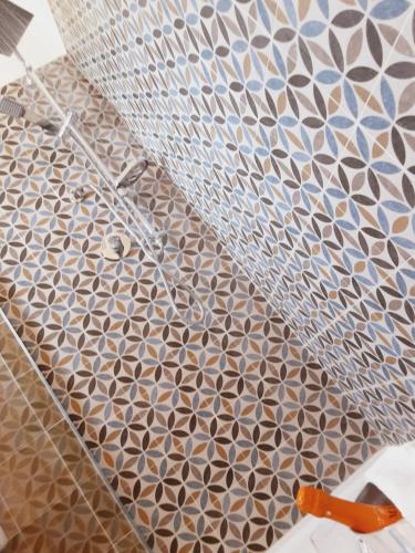 a bathroom with a tile floor with a shower at Relais LaValle in Taranto