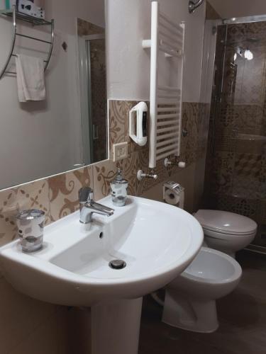 a bathroom with a white sink and a toilet at Relais LaValle in Taranto