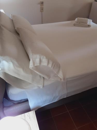 a bed with white sheets and pillows on it at Relais LaValle in Taranto