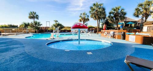 a swimming pool with a fountain in the middle at Luxury Ocean Front By Barefoot Landing in Myrtle Beach