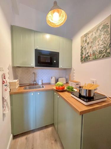 a kitchen with green cabinets and a counter top at Happy Family Apartments Maggiolino in Genova