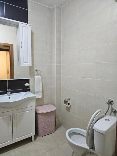 a bathroom with a white toilet and a sink at Luka Apartments in Bečići
