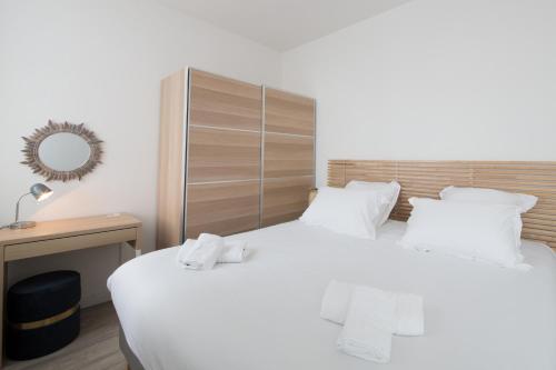a bedroom with a large white bed with white pillows at AR RANNDI - Splendide T3 de standing vue mer in Porspoder