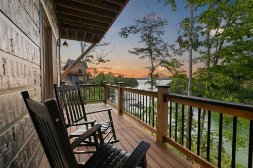 two chairs on a porch with a view of a river at Jolene Lookout in Dandridge