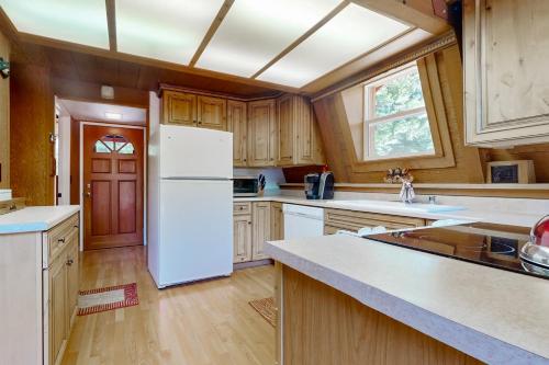 a kitchen with a white refrigerator and wooden cabinets at Graeagle Retreat in Graeagle