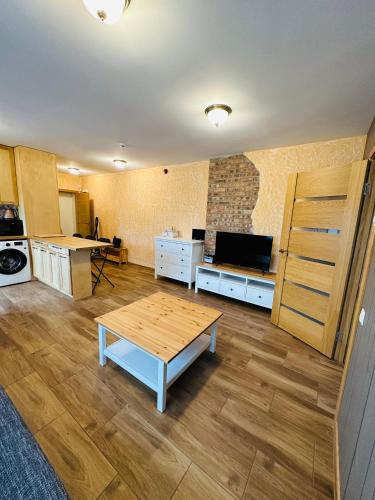 a living room with a table and a kitchen at Rožu namu apartamenti 2 in Kuldīga